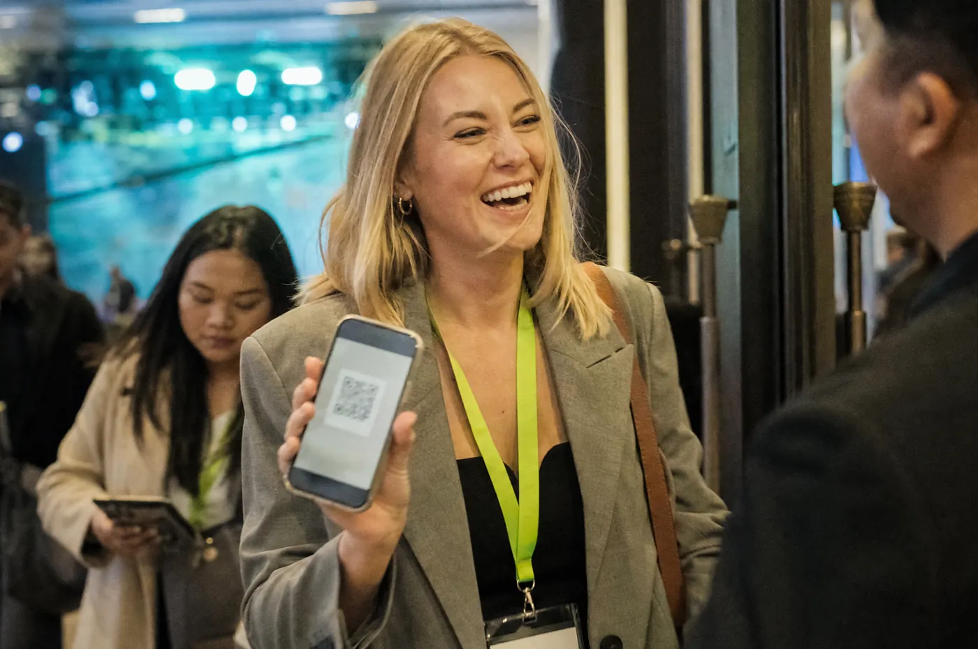A guest holding up her QR ticket at the conference entrance